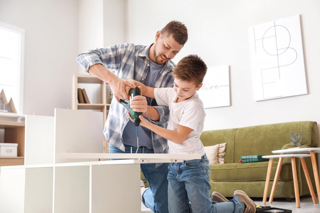 Vater und Sohn bauen zuhause Möbel zusammen